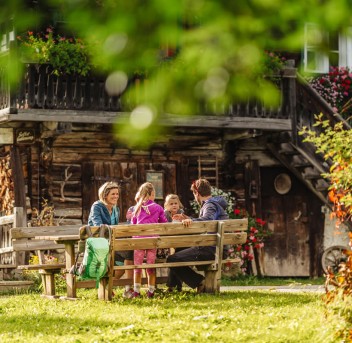 Familie Perner beim gemütlichen Zusammensitzen vor einer Hütte
